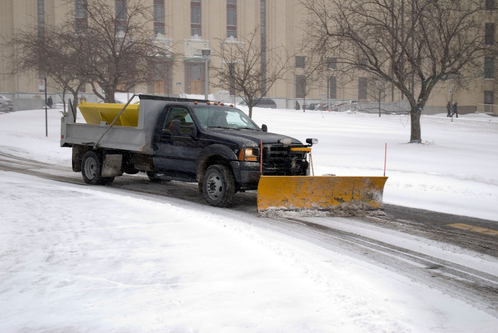 A white truck is parked in a parking lot next to a building.