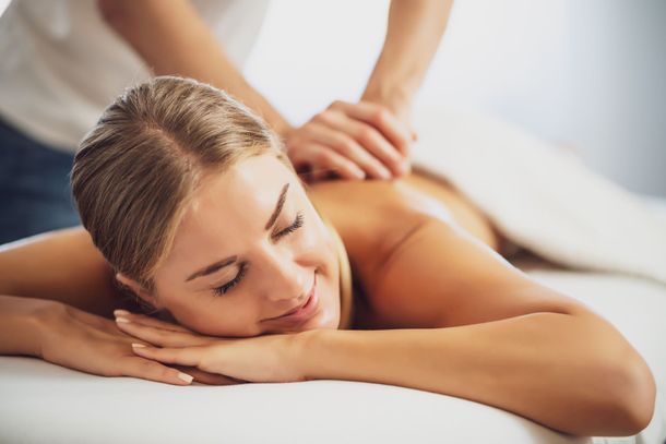 Relaxed person receiving a massage on a white spa table Relaxed person receiving a massage on a white spa table