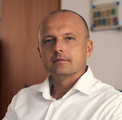 Portrait d'un homme en chemise blanche sur fond intérieur chaleureux