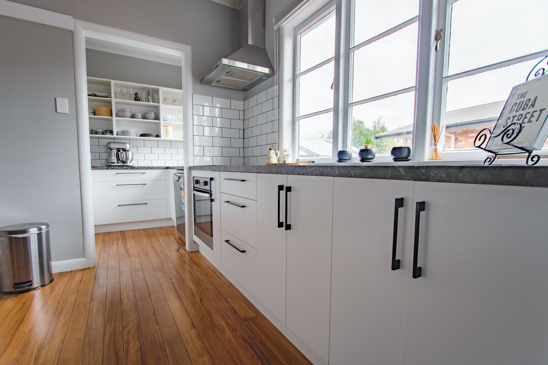 White wooden kitchen cabinets bathed in natural light from nearby windows.