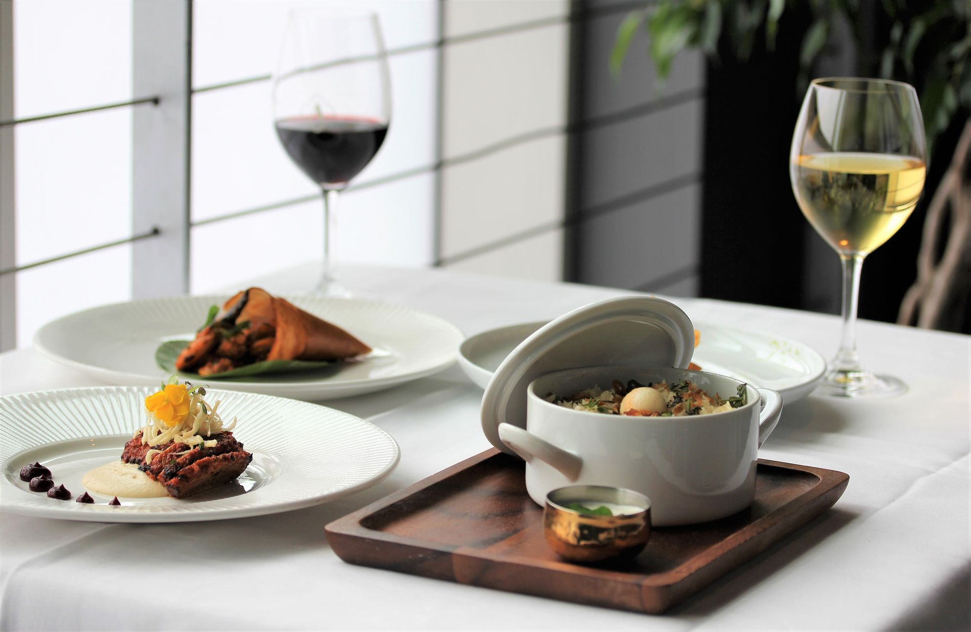 A table with plates of food and a glass of wine
