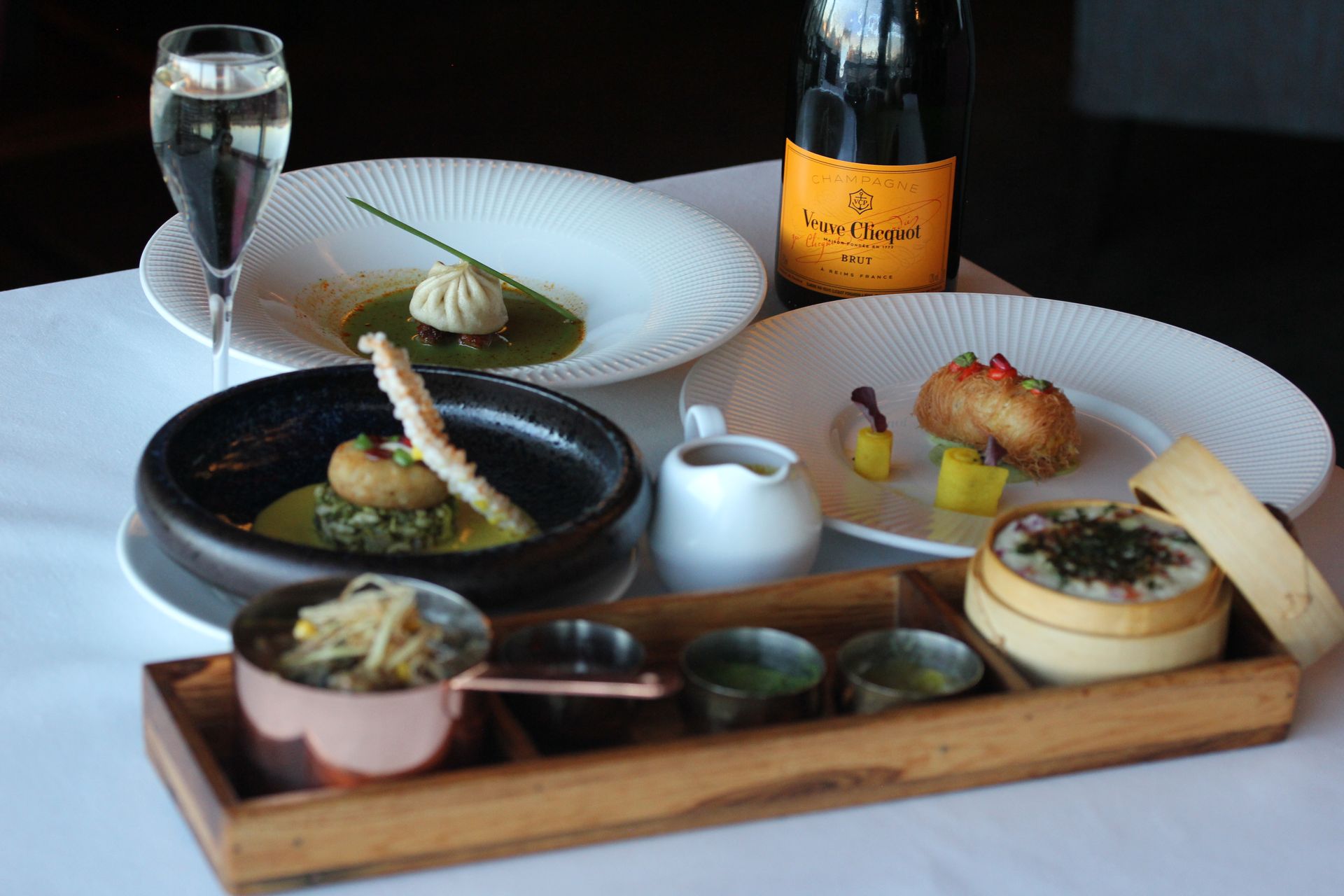 A table topped with plates of food and a bottle of champagne