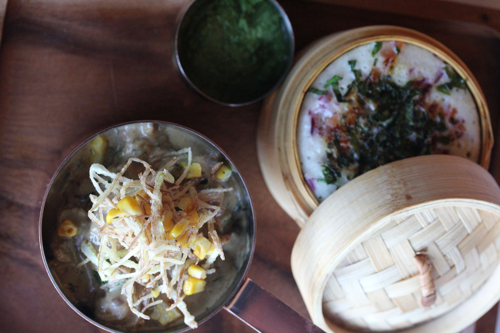 A wooden tray with two bowls of food on it