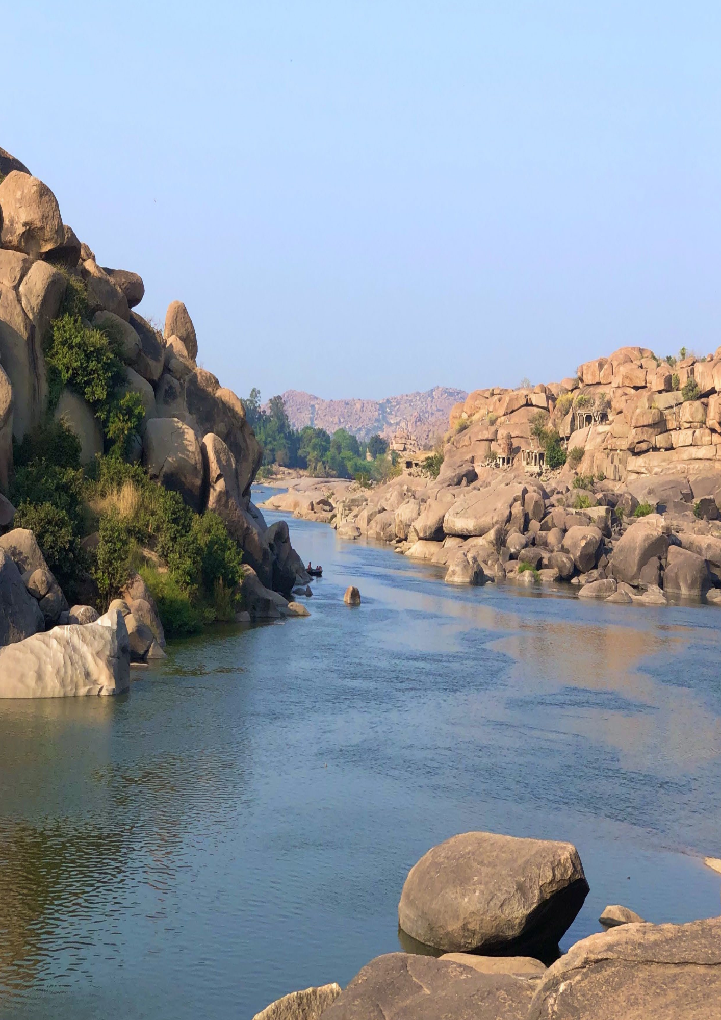 A river flowing through a rocky landscape with mountains in the background