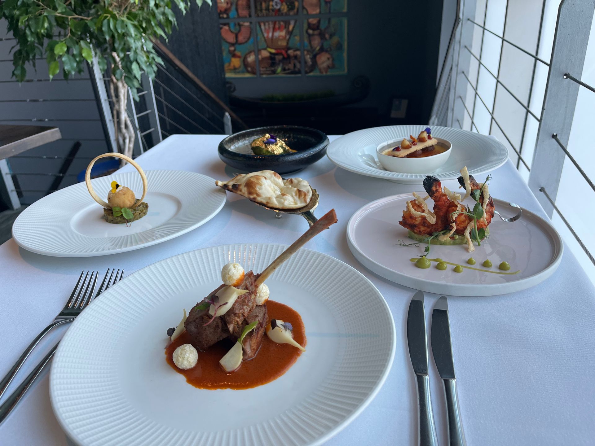 A table topped with plates of food and silverware.
