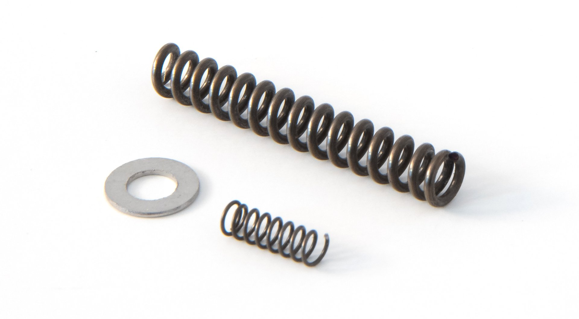 A pair of springs and a washer on a white surface.