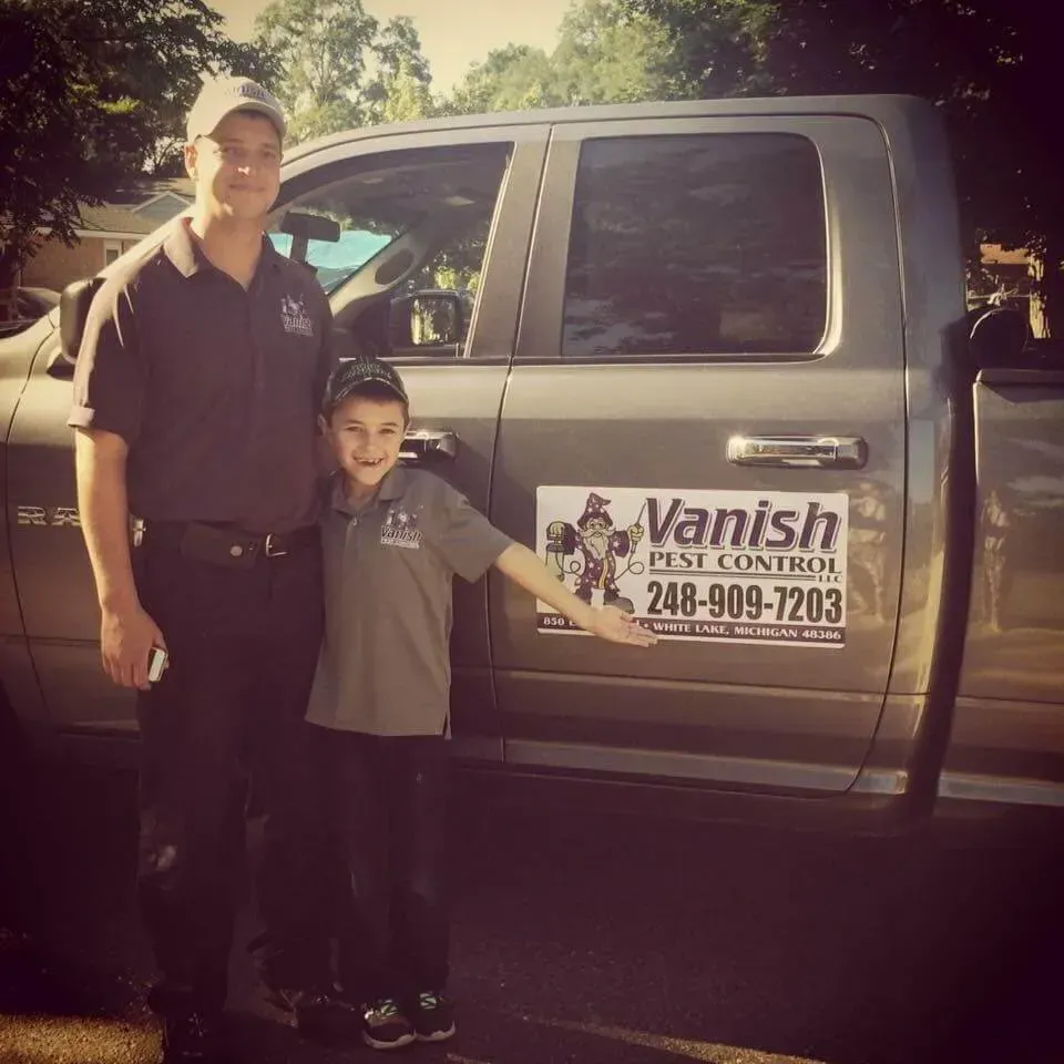 Man and boy pose beside a truck with 