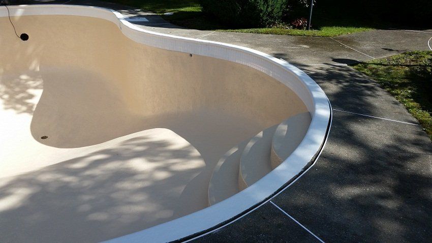 Une piscine est posée sur une allée en béton.