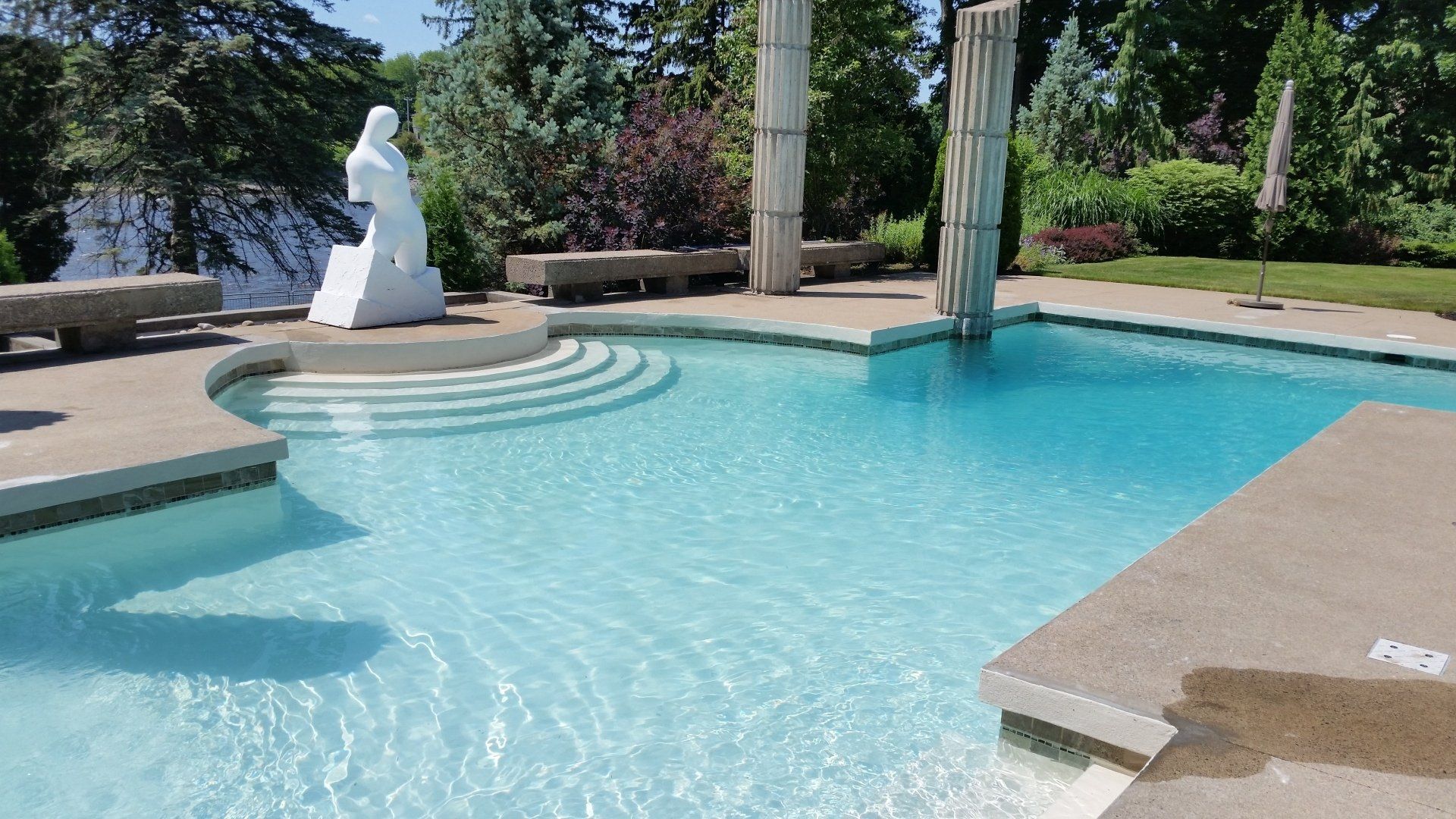 Une grande piscine avec une statue au milieu