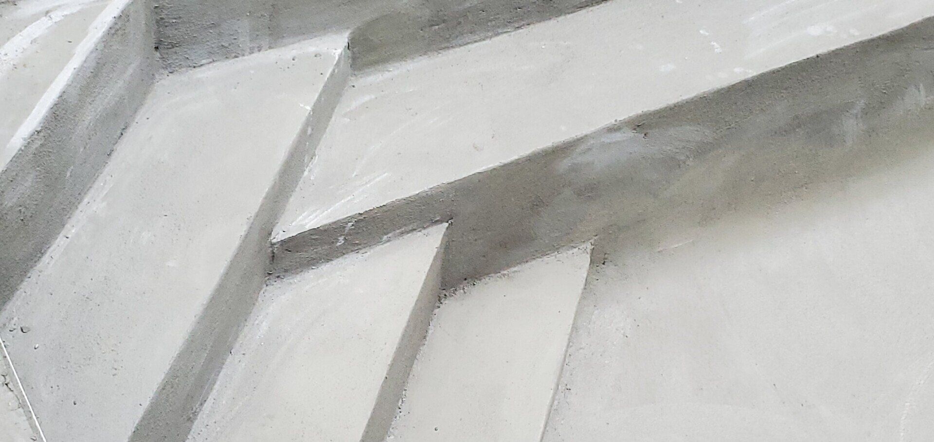 Marches en béton, gris clair, de forme angulaire, menant vers le haut.