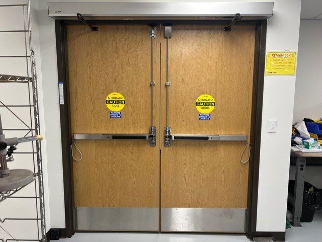 Double wooden fire doors with yellow caution decals in a hallway