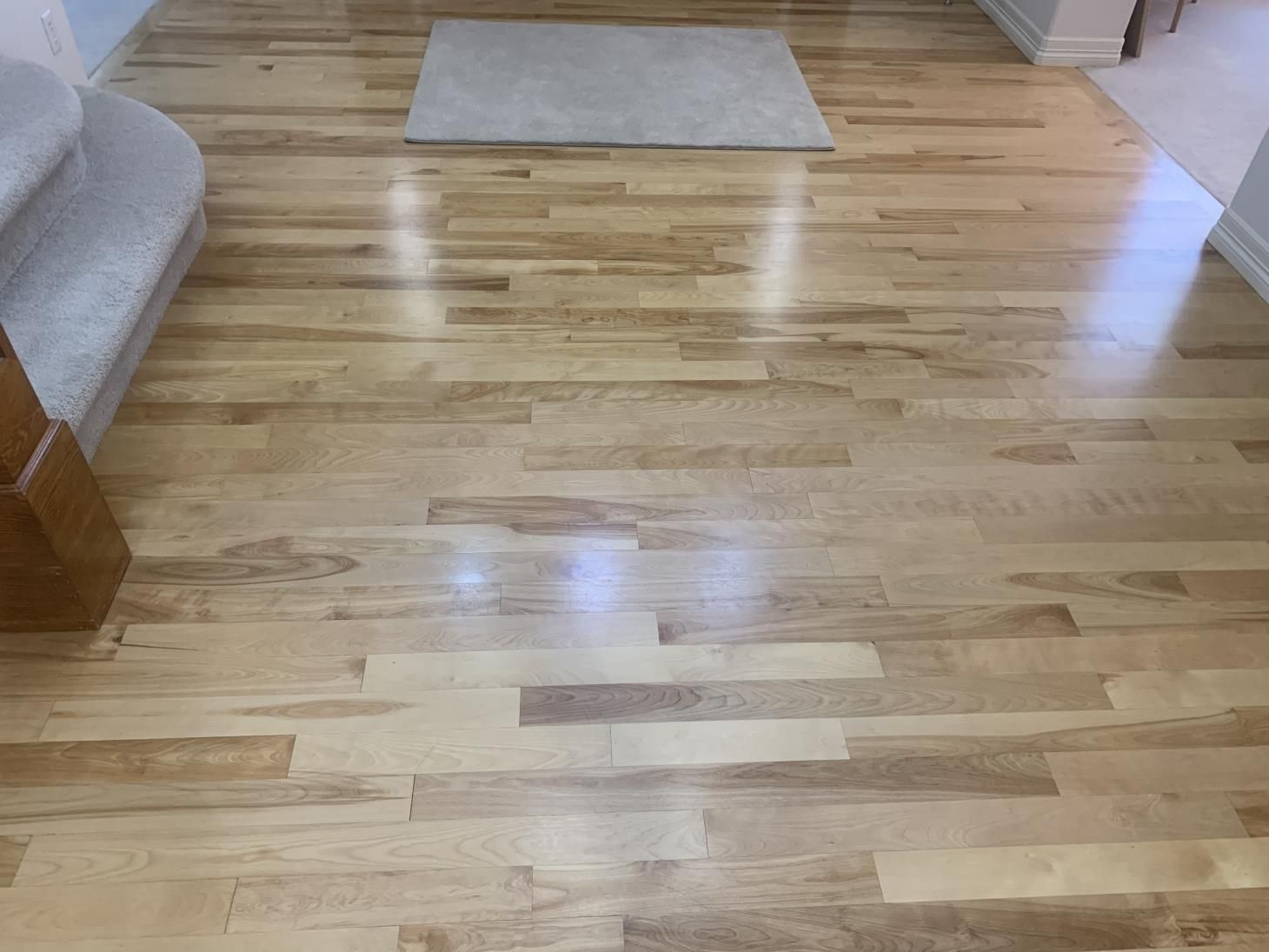 A wooden floor with a rug on it in a living room.