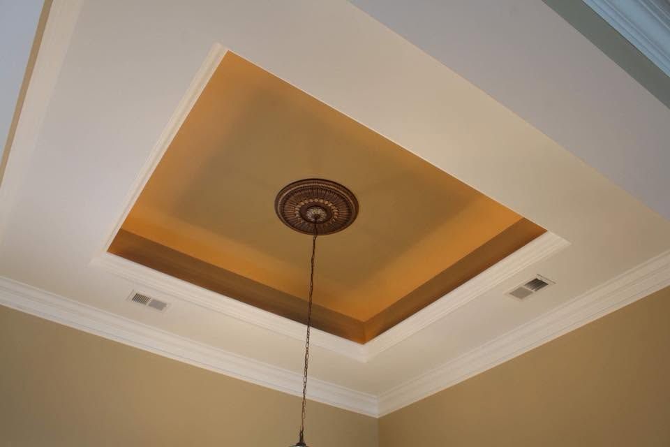 Ceiling tray with warm recessed lighting and a hanging pendant fixture