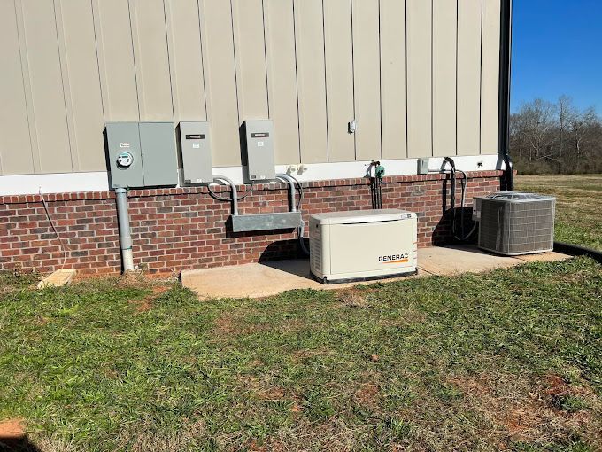A generator is sitting on the side of a building next to a brick wall.