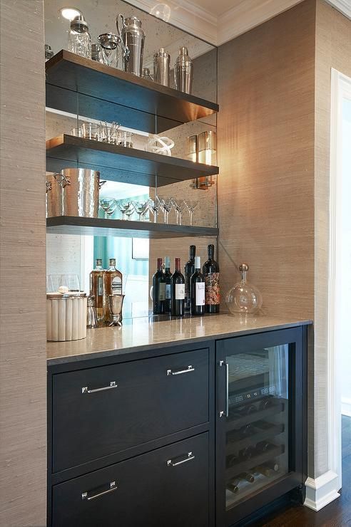 A bar with bottles of wine and glasses on the counter.
