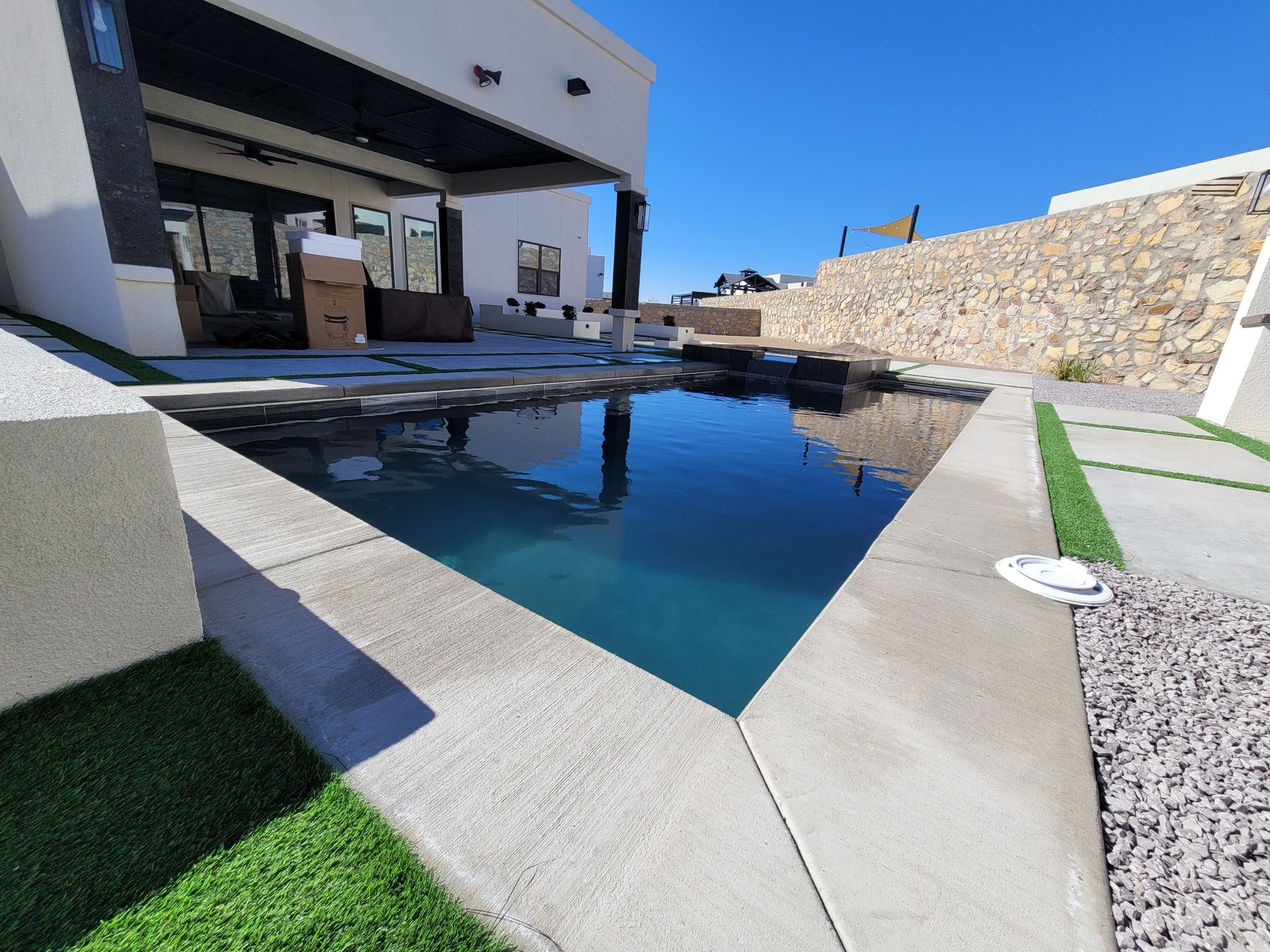 A large swimming pool in front of a house