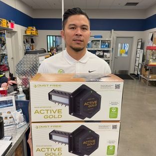 Store employee behind stacked Active Gold product boxes in a retail shop