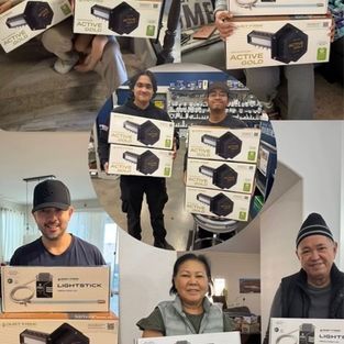 Several people indoors holding boxed electronic products for a group giveaway photo