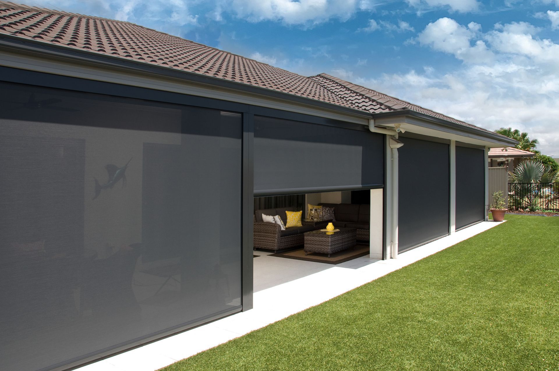 A Black Awning is Hanging From the Side of a Building — Tully Blinds in Tully, QLD