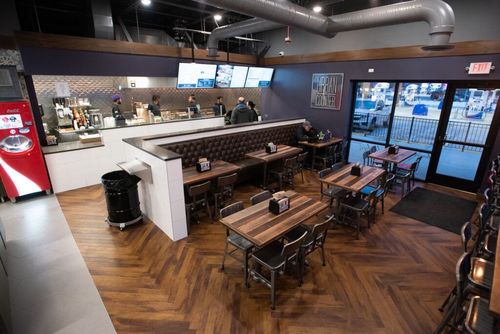 Restaurant interior with wooden tables, booths, and a service counter.