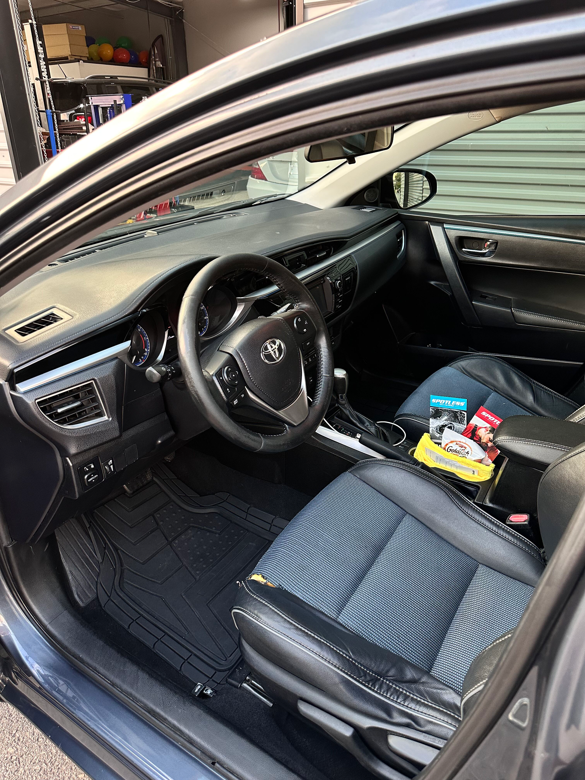 Interior of a dark gray car with black seats. The dashboard, steering wheel, and front passenger seat are visible.