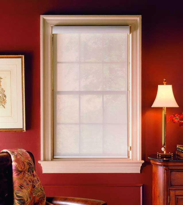 A living room with red walls and a white window