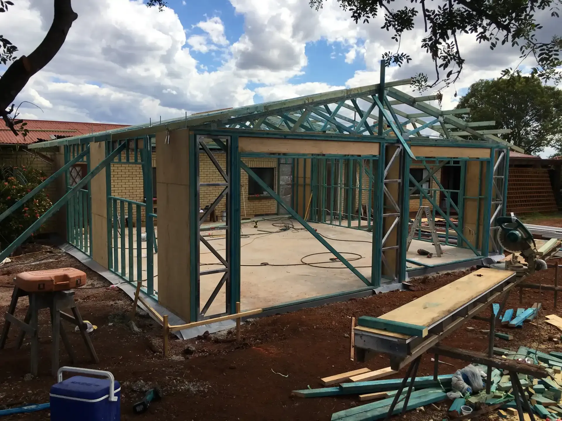 Construction of a building frame made of green metal and brown panels, outdoors. — Wards Group QLD In Kingaroy, QLD