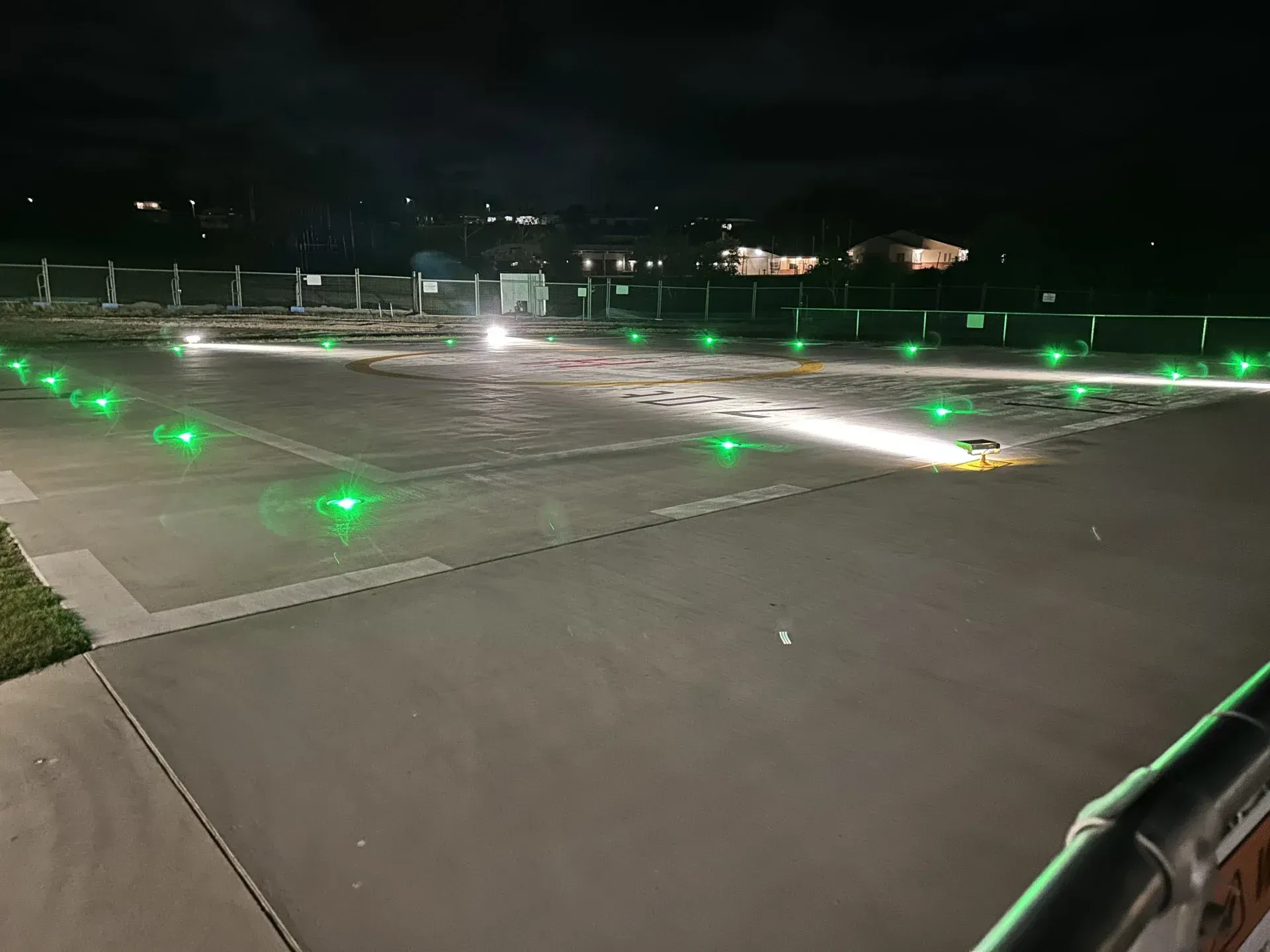 Nighttime view of a lit airfield runway, marked with green lights, extending into the darkness. — Wards Group QLD In Kingaroy, QLD