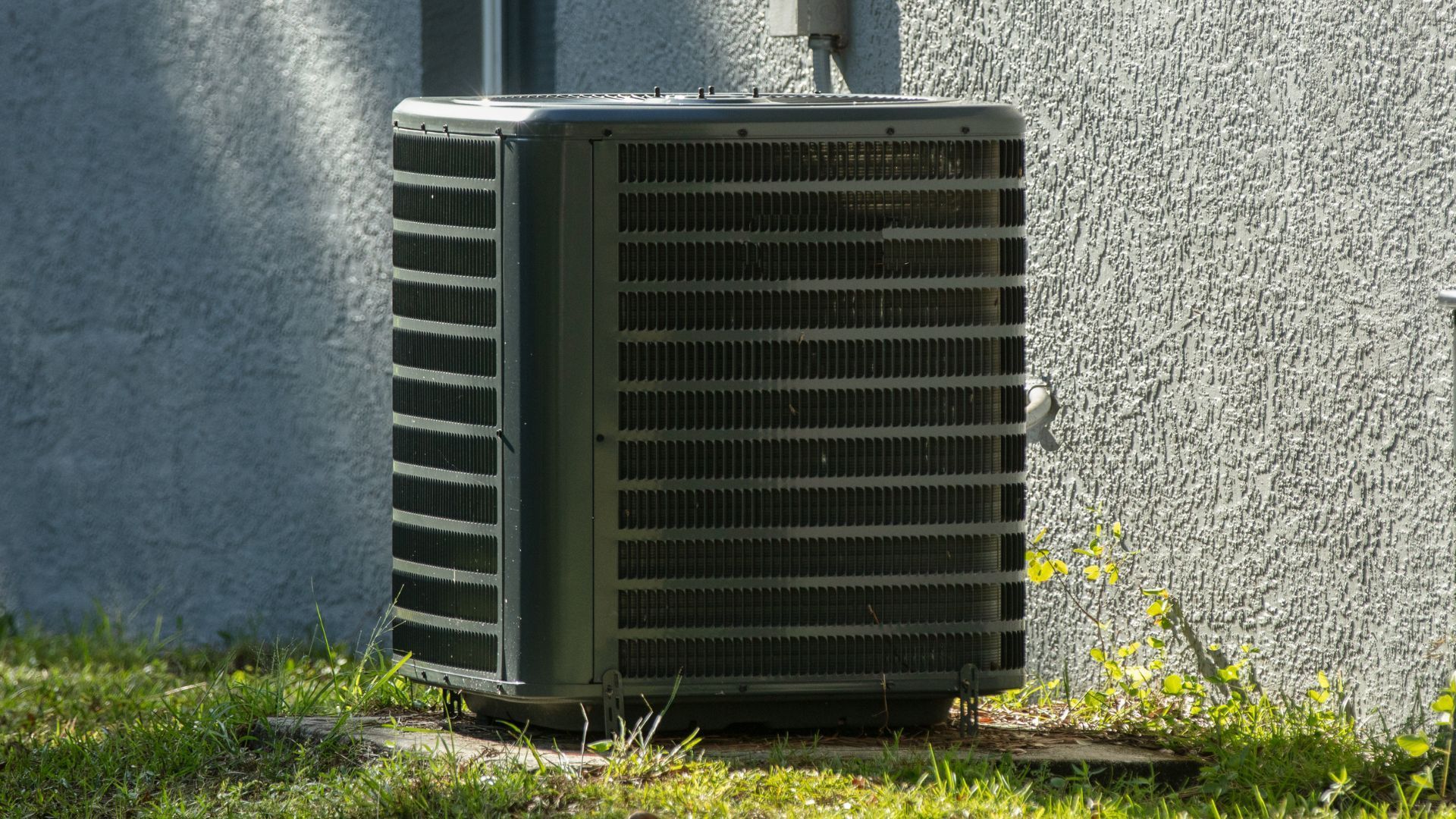 A large air conditioner is sitting on the side of a building.