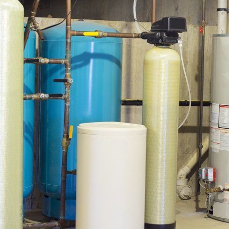A water filter is sitting next to a white tank