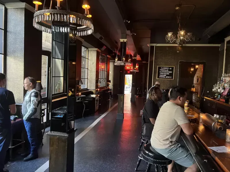 A group of people are sitting at a bar in a restaurant.