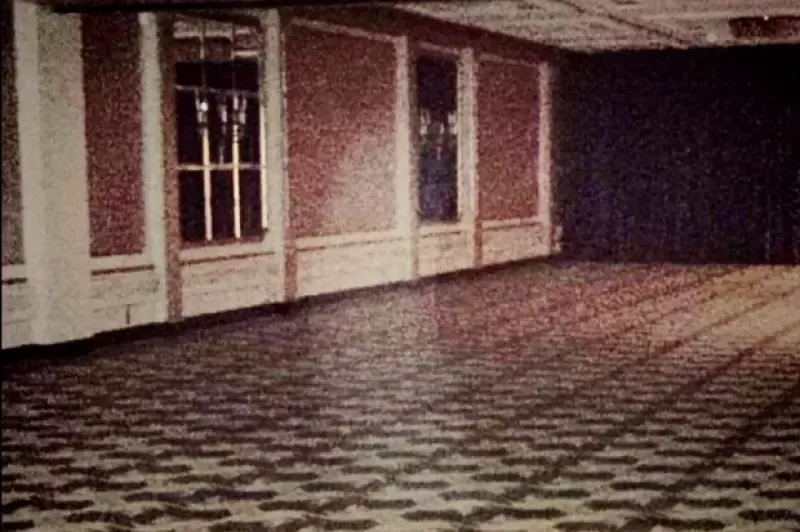A black and white photo of an empty room with a checkered floor.