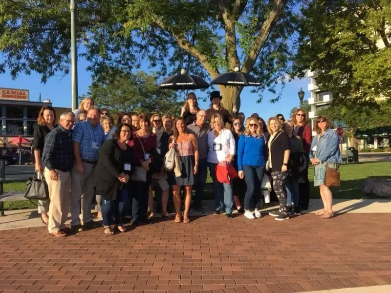 A group of people are posing for a picture in a park.