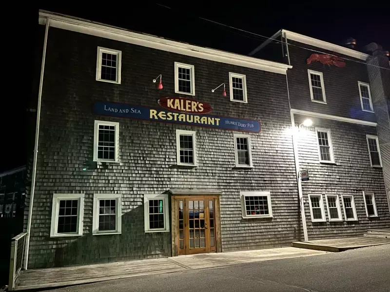 Kaler's Restaurant, two-story weathered wood building lit at night. Sign over the entrance.