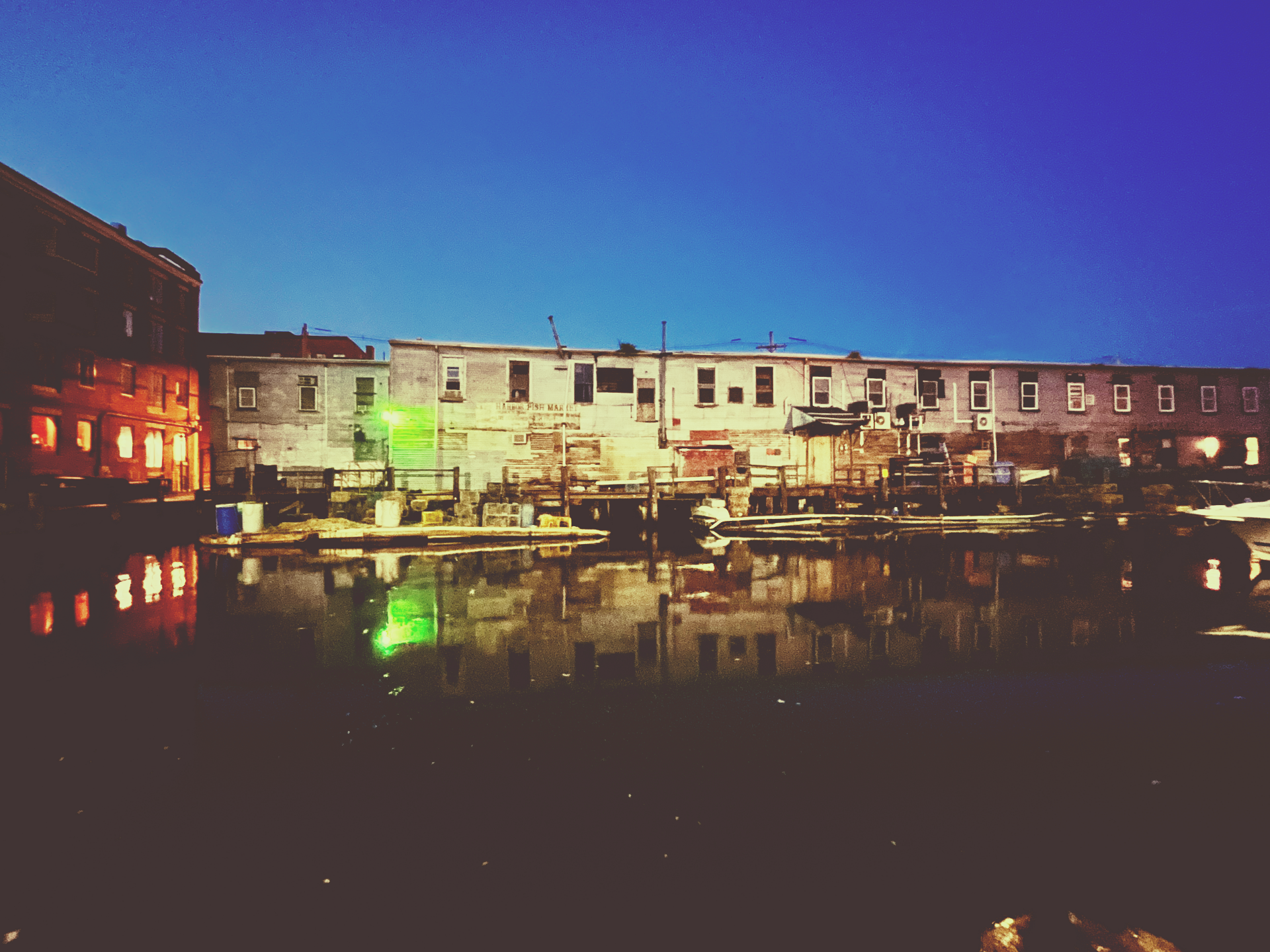 A row of buildings next to a body of water at night.