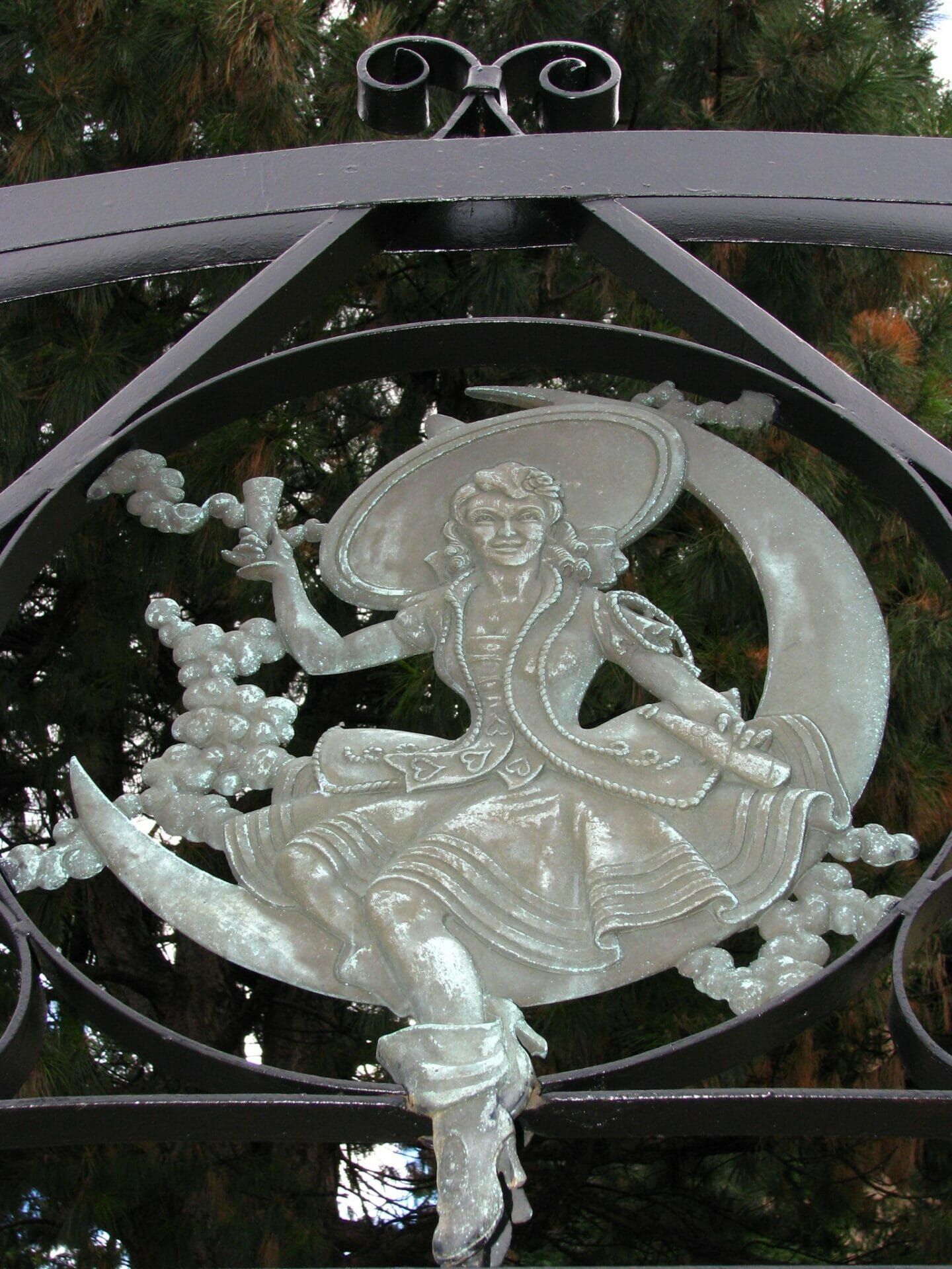 A statue of a woman sitting on a crescent moon