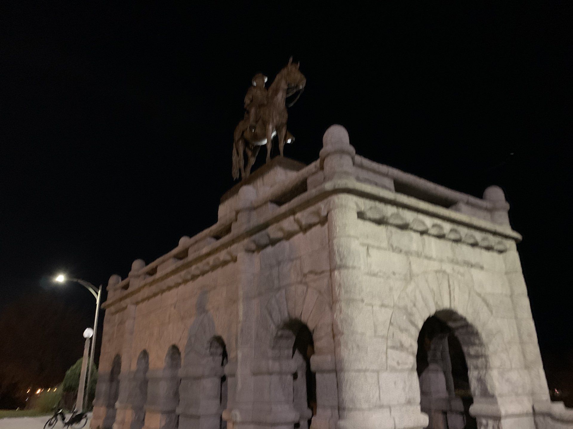A statue of a man riding a horse on top of a stone building