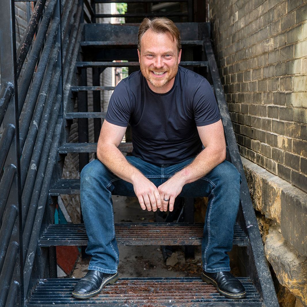 A man is sitting on a set of stairs.