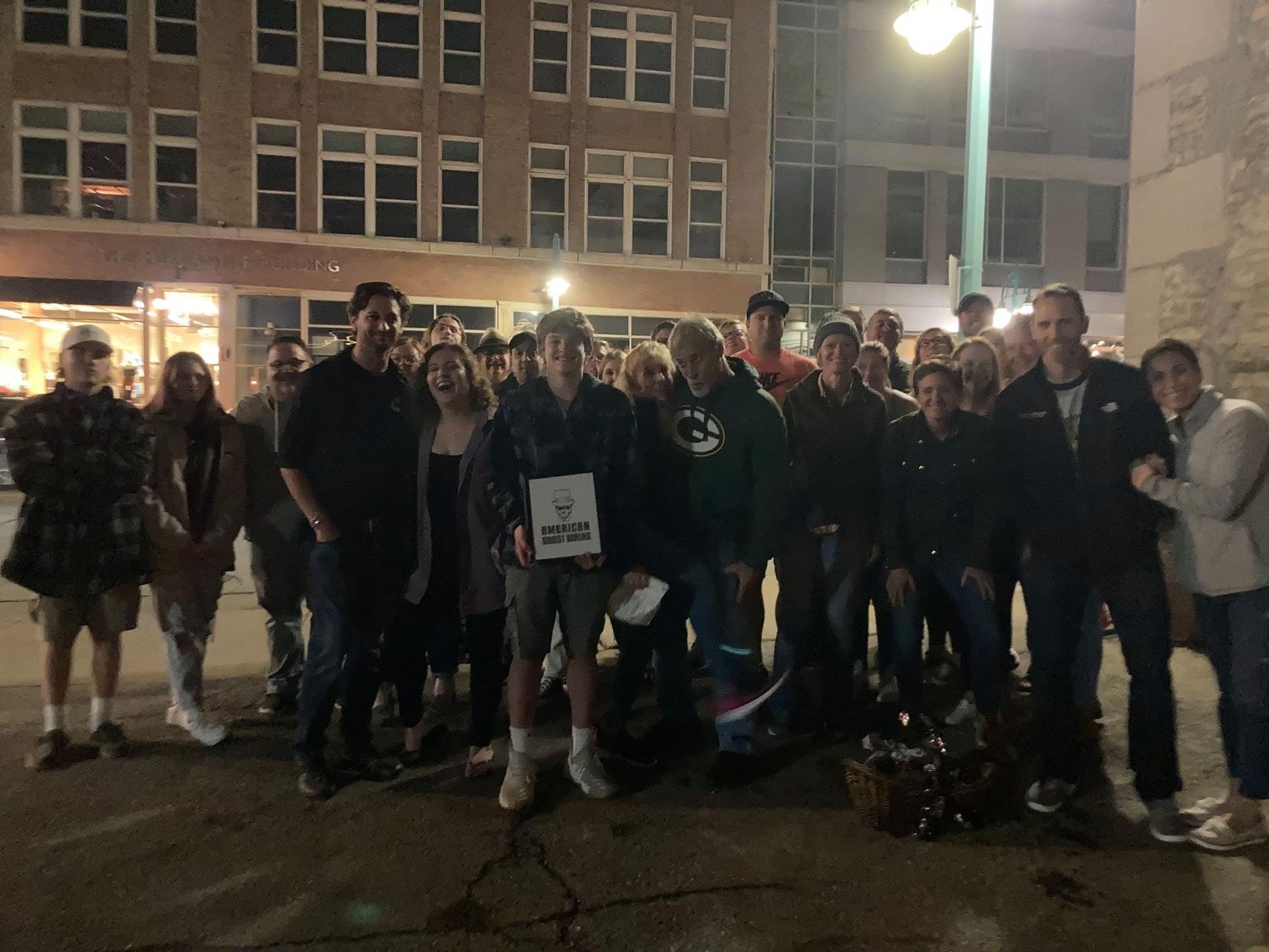 A group of people standing in front of a building with the number 33 on their shirt