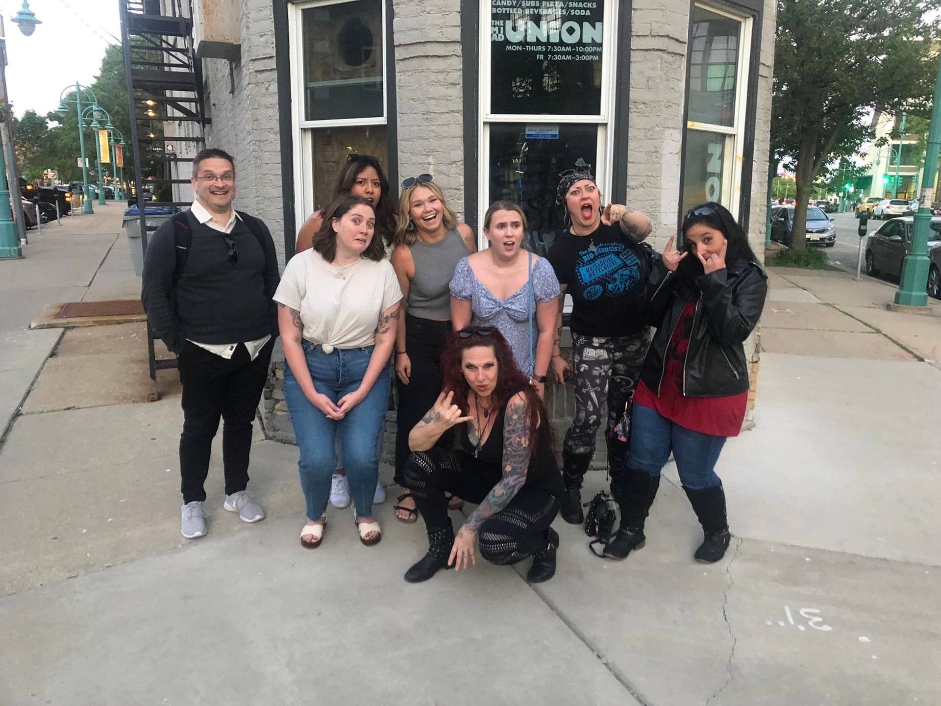 A group of people posing for a picture in front of a building that says houston