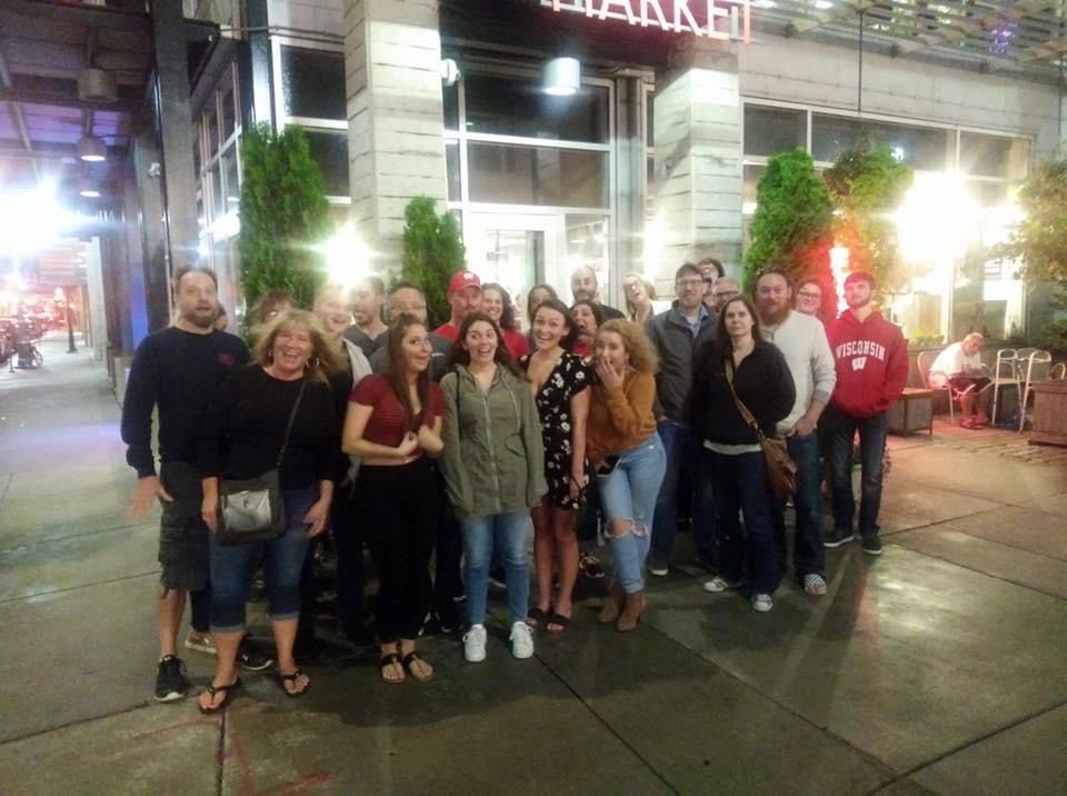 A group of people are posing for a picture in front of a building.