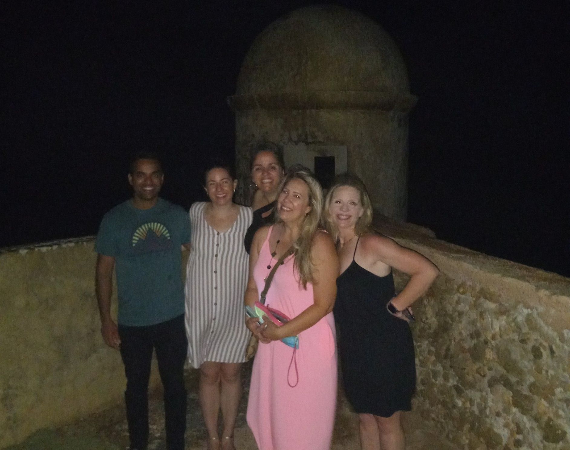 A group of people posing for a picture at night