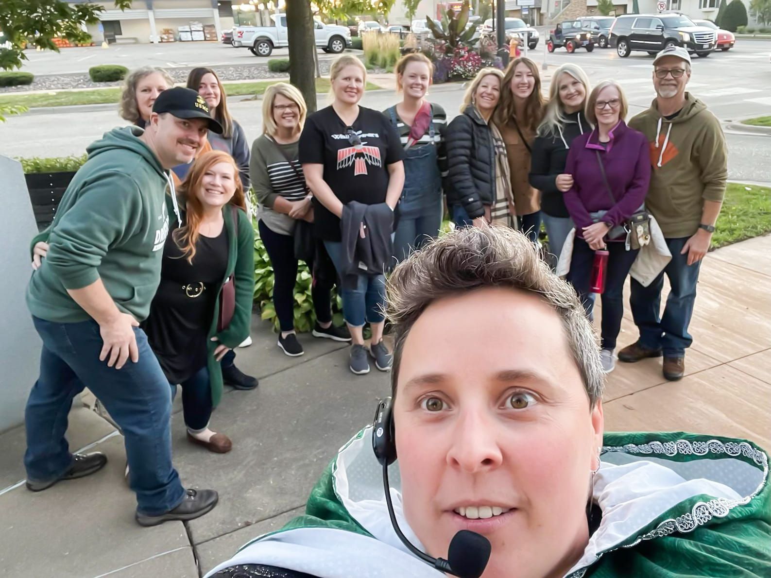 A group of people are posing for a picture including a woman wearing headphones