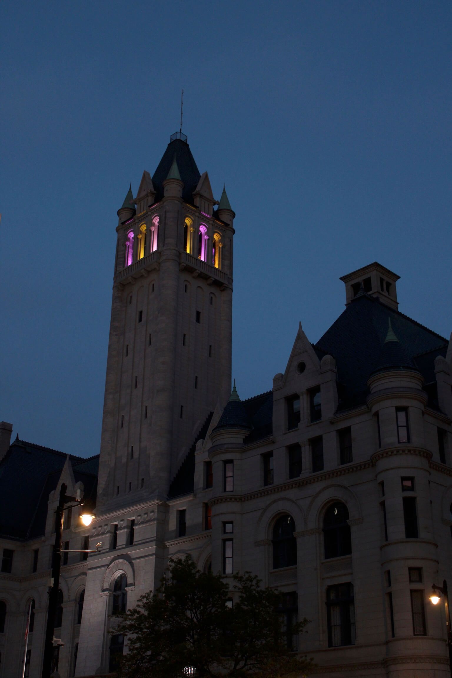 A large building with a clock tower lit up at night