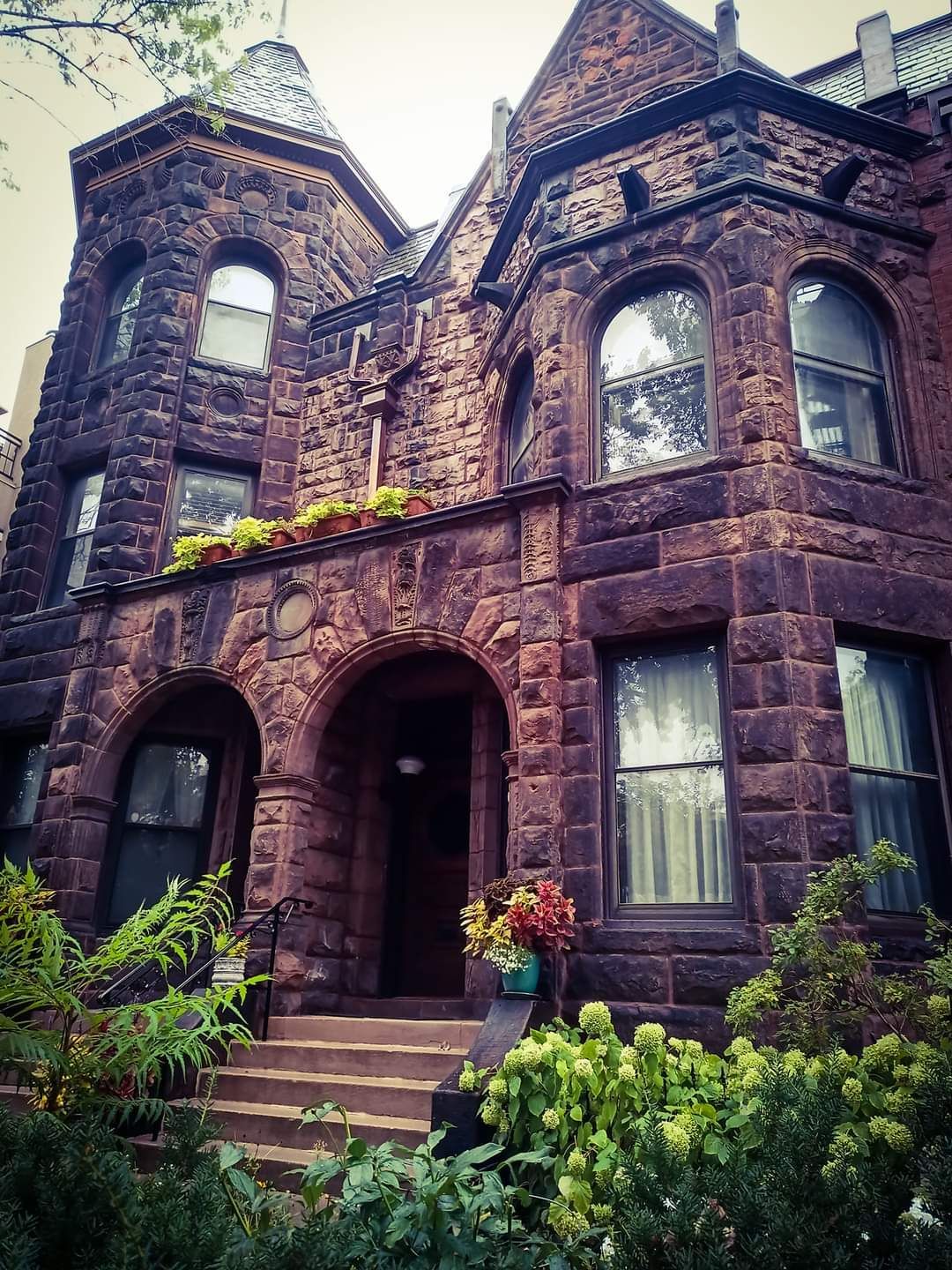 A large brick building with arched windows and stairs