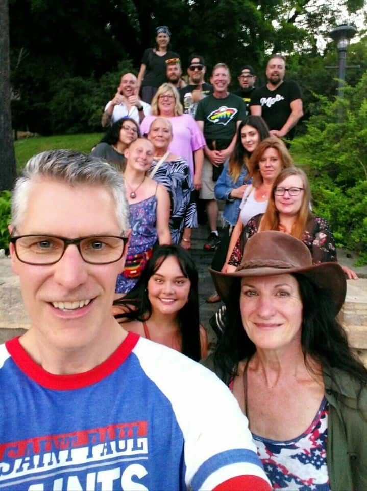 A group of people are posing for a picture and one of them is wearing a shirt that says saint paul 's