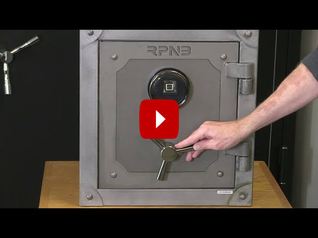 A person is opening a safe with a key.