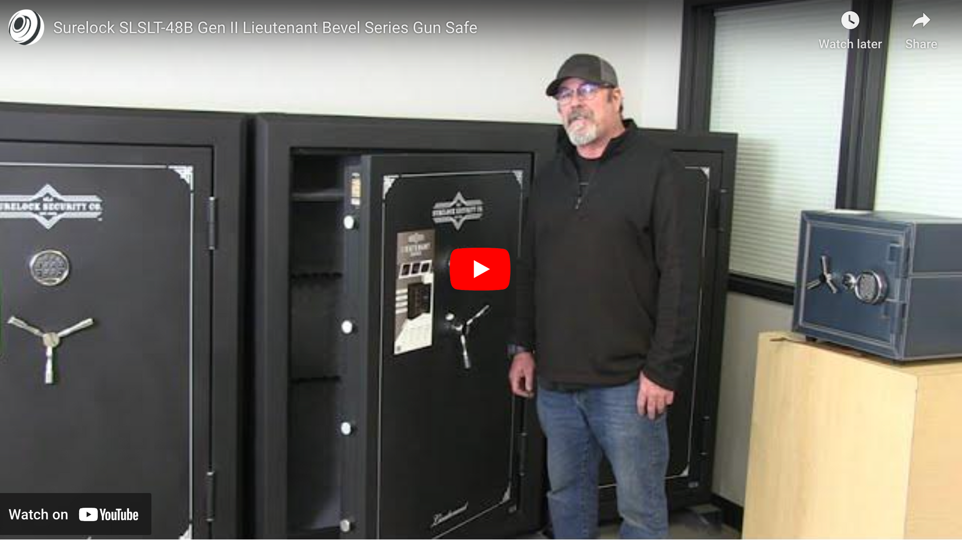 A man is standing in front of a safe in a room.