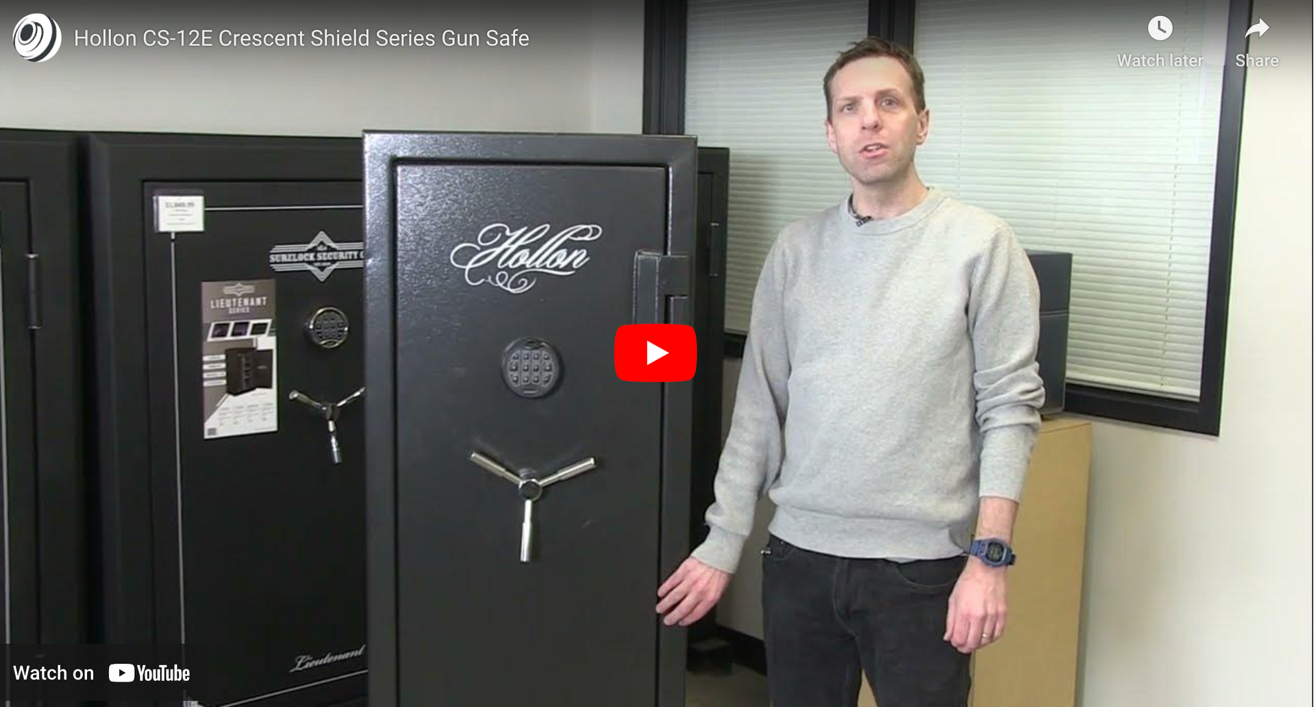A man is standing in front of a safe in a room.