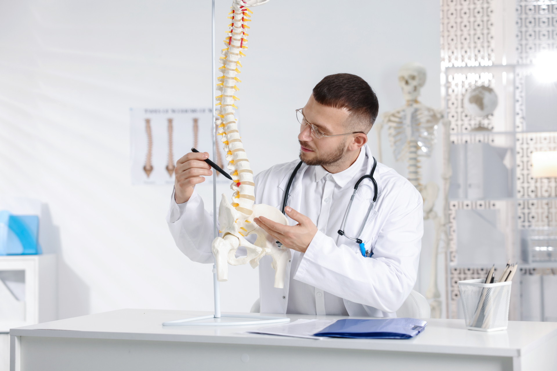 Chiropractor adjusting a patient lying face down on a treatment table in a clinic